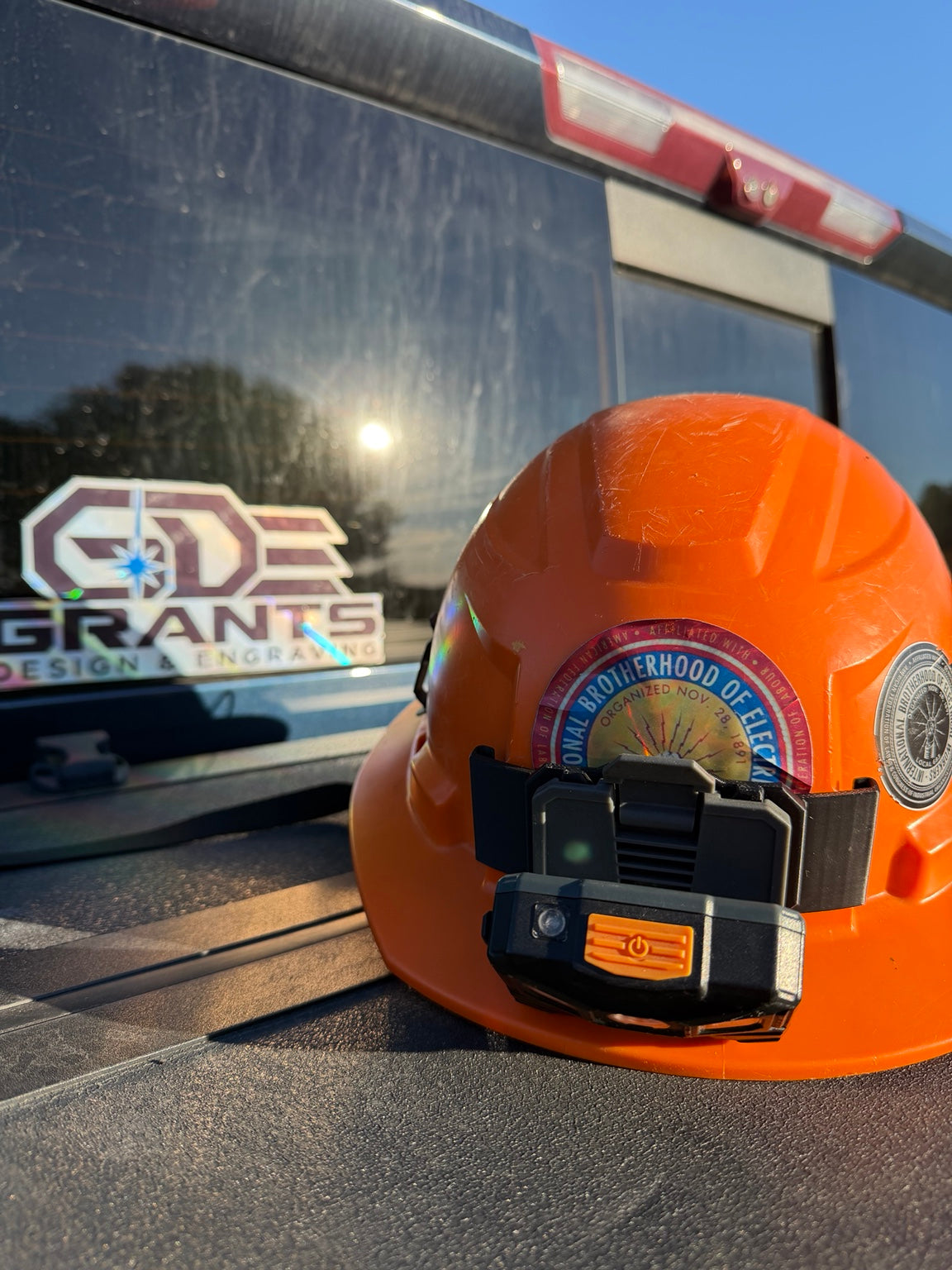 Klein Tools light attached to the back of an orange Milwaukee BOLT hard hat