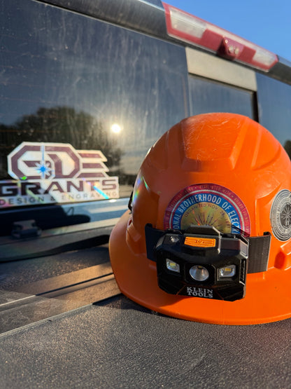 Klein Tools light mounted on an orange Milwaukee BOLT hard hat, front view